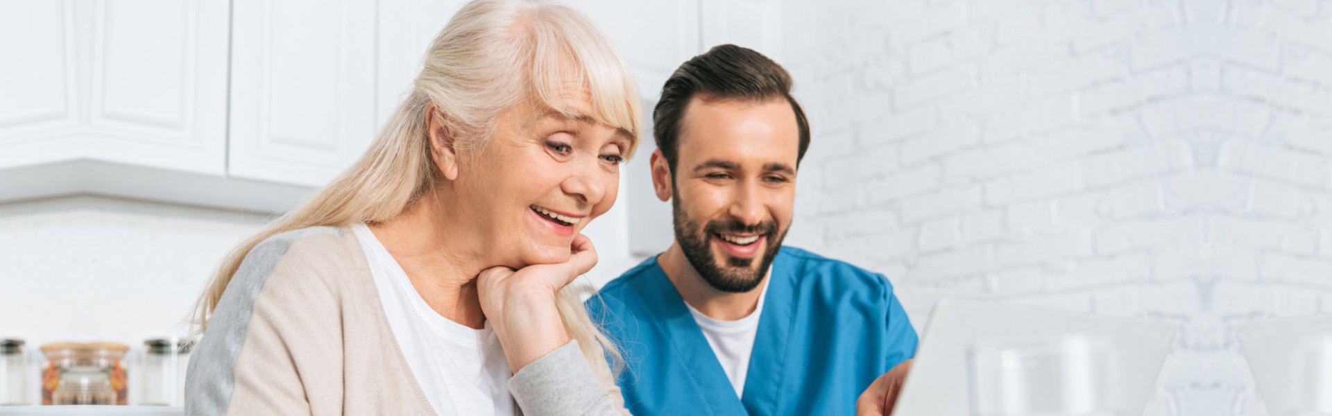 senior woman and a male nurse using laptop